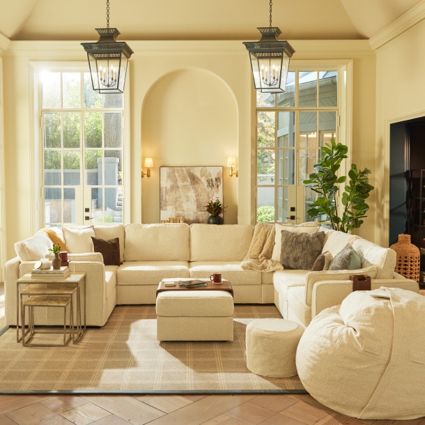 Living room with a large sactional couch set-up and a dog on the side.
